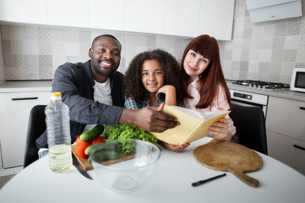 A family reading a book together at their kitchen table